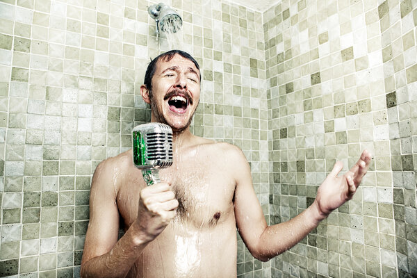 Mann mit Mikrofon unter der Dusche | © Getty Images